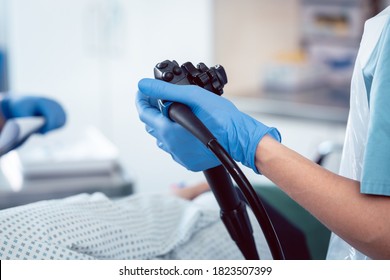 Doctor proctologist holding endoscope during colonoscopy