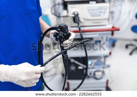 Doctor proctologist holding endoscope during colonoscopy. Probe colonoscope. Doctor gastroenterologist with probe to perform gastroscopy and colonoscopy