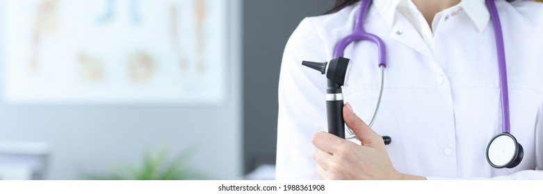 Doctor In Protective Mask Holds An Otoscope In His Hands