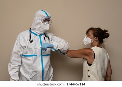 Doctor In A Protective Suit Greeting A Patient With An Elbow Salute, For The Prevention Of Coronavirus