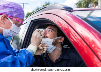A doctor in a protective suit taking a nasal swab from a person to test for possible coronavirus infection - Shutterstock ID 1687321885