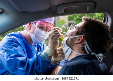 A doctor in a protective suit taking a nasal swab from a person to test for possible coronavirus infection - Shutterstock ID 1687321891