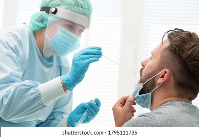Ärztin in einem Schutzanzug, der einen Hals- und Nasenschleifer von einem Patienten zur Untersuchung auf eine mögliche Infektion mit Coronavirus entnimmt