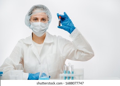 doctor in protective uniform with mask holding blood sample with coronavirus