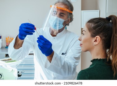 Doctor In Protective Workwear Preparing For Taking A PCR Test From Young Woman In The Hospital