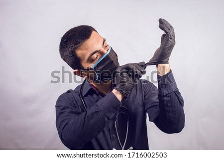 doctor puts on gloves on a gray background