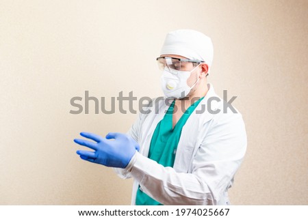 The doctor puts on gloves. On a light background. High quality photo