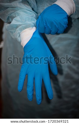 The doctor puts on hands, sterile surgical gloves that protect against coronavirus
