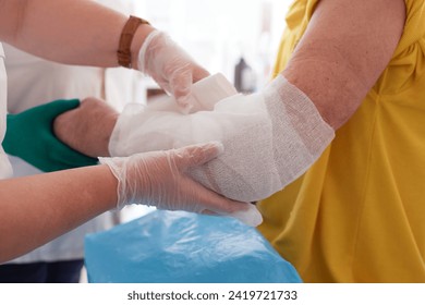 doctor puts a plaster on the arm of a patient in the hospital with a broken arm - Powered by Shutterstock