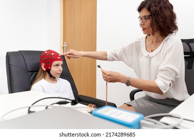Doctor putting electrodes on a girl in a biofeedback session - Shutterstock ID 2174289685