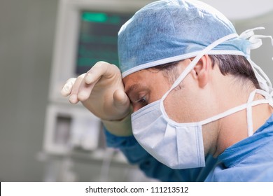 Doctor putting his hand on his forehead in hospital ward, Healthcare workers in the Coronavirus Covid19 pandemic - Shutterstock ID 111213512
