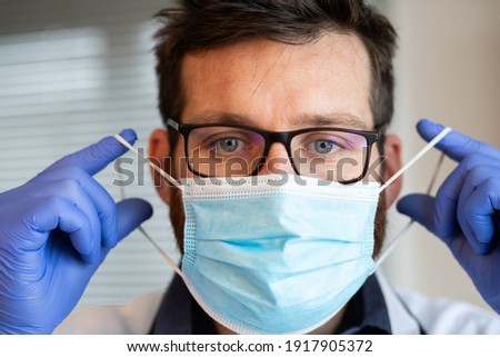 doctor putting on medical mask