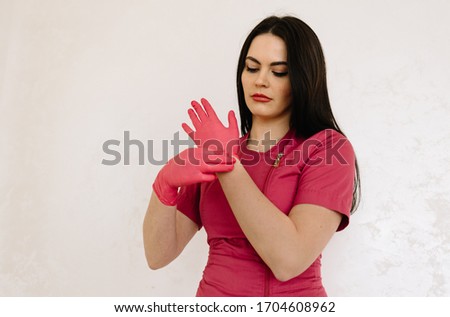 Doctor putting on pink surgical gloves