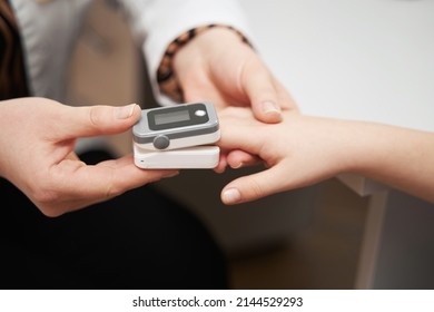 Doctor Putting Pulse Oximeter Sensor On Child Finger