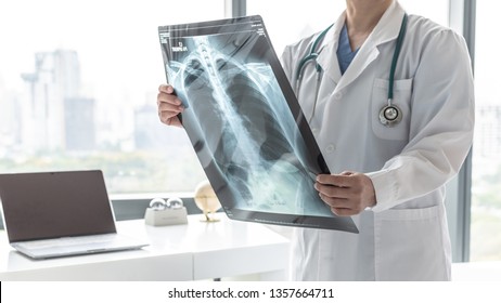Doctor with radiological chest x-ray film for medical diagnosis on patient’s health on COVID-19, asthma, lung disease and bone cancer illness, healthcare hospital service concept  - Shutterstock ID 1357664711