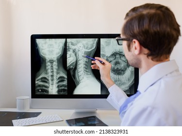 Doctor radiologist analyzing a cervical spine x-ray of a patient with spinal chronic pain.
 - Powered by Shutterstock