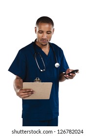 Doctor Reading From A Clipboard While Holding A Cell Phone.