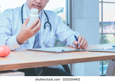 Doctor Reading Drug Label Of Bottle Medicine For Give Medicine To Patients. Medical And Health Care Concept.