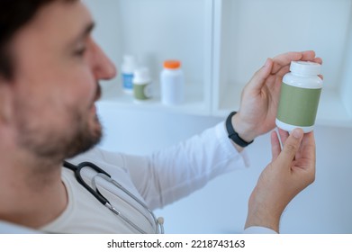 Doctor Reading The Label On A Dietary Supplement