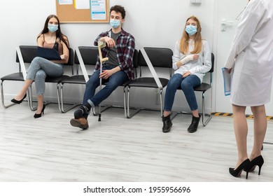 The doctor reads out the next person in line. During a pandemic everyone must wear protective masks - Shutterstock ID 1955956696