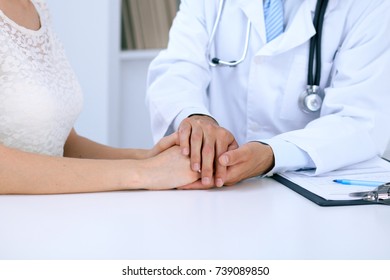 Doctor reassuring his female patient by touching her hands while talking. Symbol of support and trust in medicine - Shutterstock ID 739089850