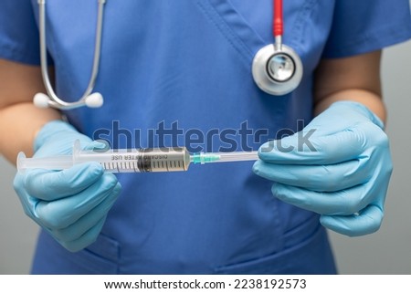 the doctor removes the cap from the syringe. syringe with needle. 