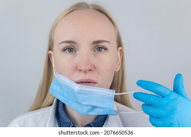 Doctor Removes The Protective Mask And Shows Irritation On Face Skin. Antiviral Measures. Means Of Protection Against Covid 19. Long Wearing Of A Mask. Acne On Face And Chafing. Dry Lips And Red Dots