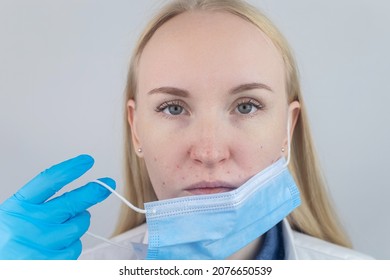 Doctor Removes The Protective Mask And Shows Irritation On Face Skin. Antiviral Measures. Means Of Protection Against Covid 19. Long Wearing Of A Mask. Acne On Face And Chafing. Dry Lips And Red Dots