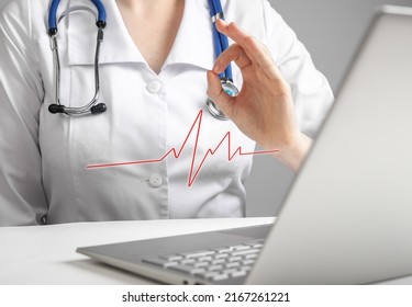 Doctor Reporting Electrocardiogram Results To Patient Online Using Laptop. Telemedicine, Telehealth Concept. Woman In Lab Coat Showing No Heart Problems With Ok Hand Gesture Via Videocall. Photo