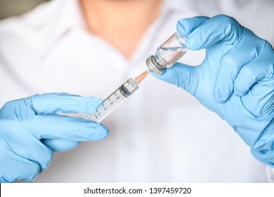 Doctor, Researcher Or Scientist Hand In Blue Glove Holding Flu, Measles, Rubella Or Hpv Vaccine And  Syringe With Needle Vaccination For Baby, Child, Woman Or Man Shot, Medicine Vial Dose Injection