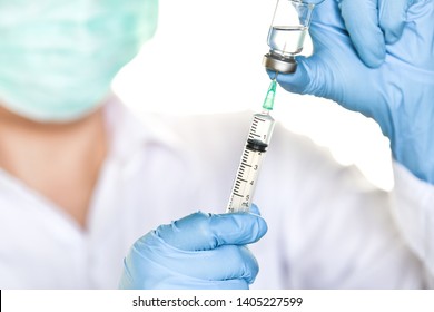 Doctor, Researcher Or Scientist Hand In Blue Glove Holding Flu, Measles, Rubella Or Hpv Vaccine And  Syringe With Needle Vaccination For Baby, Child, Woman Or Man Shot, Medicine Vial Dose Injection