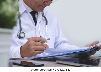 Doctor review patient information, writing prescription and working on laptop computer in medical office in hospital, close up - Powered by Shutterstock