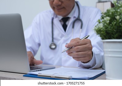 Doctor review patient information, writing prescription and working on laptop computer in medical office in hospital, close up, telemedicine, medical research concept - Powered by Shutterstock