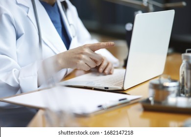 Doctor Reviewing Medical Data With Laptop