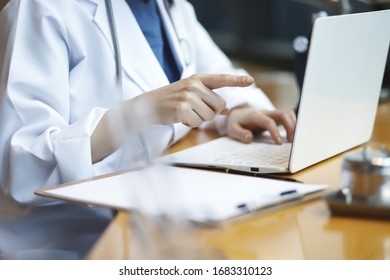 Doctor Reviewing Medical Data With Laptop