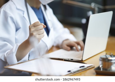 Doctor Reviewing Medical Data With Laptop