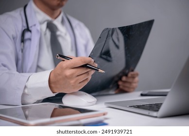 Doctor reviewing X-ray image. Focuses on medical analysis, diagnosis, and professional care. Ideal for healthcare, radiology, and clinical presentations. - Powered by Shutterstock