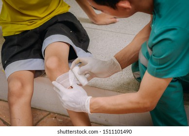 Doctor is rewinding knee bandage to young boy. - Powered by Shutterstock