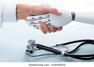 Doctor And Robot Shaking Hands Over Stethoscope