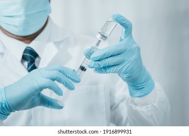 A Doctor Or Scientist In The COVID-19 Medical Vaccine Research And Development Laboratory Holds A Syringe With A Liquid Vaccine To Study And Analyze Antibody Samples For The Patient.
