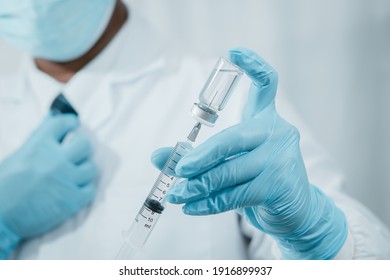 A Doctor Or Scientist In The COVID-19 Medical Vaccine Research And Development Laboratory Holds A Syringe With A Liquid Vaccine To Study And Analyze Antibody Samples For The Patient.
