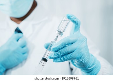 A doctor or scientist in the COVID-19 medical vaccine research and development laboratory holds a syringe with a liquid vaccine to study and analyze antibody samples for the patient.
 - Powered by Shutterstock