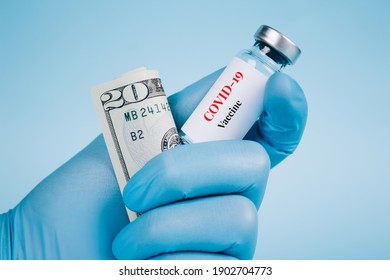 Doctor Or Scientist Holding 20 Dollars Bill And Vial Dose Of COVID-19 Vaccine Against Blue Background With Copy Space - Global Vaccination And Money Laundering Concept, Vaccine Cost. Selective Focus