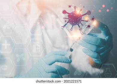 A doctor or scientist in a medical vaccine research and development lab for the mutated COVID-19 holds a syringe containing the liquid vaccine. To study and analyze antibody samples for patients. - Powered by Shutterstock