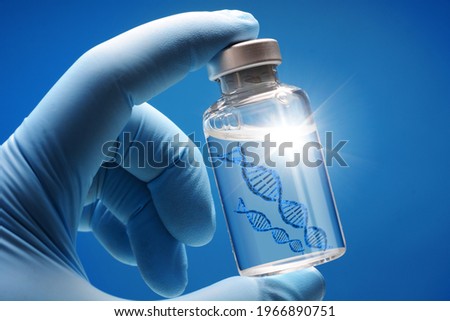 Doctor or scientist shows a vial of genetic agent as a vaccine or therapy against Corona or Covid-19 as a symbolic image