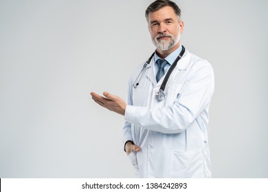 Doctor senior man, medical professional holding something in empty hand isolated over white background - Powered by Shutterstock