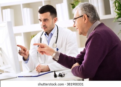 Doctor And Senior Patient Pointing On Computer