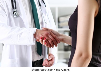 Doctor shake hand as hello with patient in office closeup. Welcoming friend, introduction or thanks gesture, consultation work, thankful client talk, team trust, communication teamwork deal concept - Shutterstock ID 653723875
