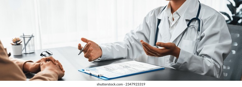 Doctor show medical diagnosis report and providing compassionate healthcare consultation to young patient in doctor clinic office. Doctor appointment and medical consult concept. Neoteric - Powered by Shutterstock