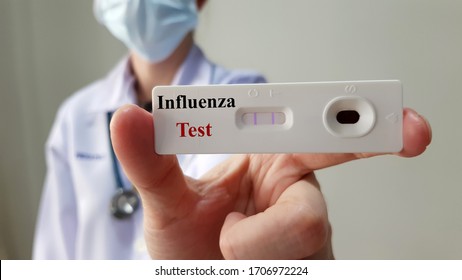 Doctor show positive rapid laboratory influenza test for diagnosis influenza virus infection or flu disease, ready for screening and treatment. Medical infectious test and investigation concept - Shutterstock ID 1706972224